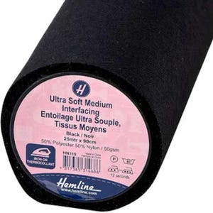 Könnte beinhalten: Eine Rolle schwarzes Vliesstoff mit einem rosa-weißen Etikett. Das Etikett lautet "Ultra Soft Medium Interfacing" und enthält die Marke "Hemline". Der Stoff ist 25 Meter mal 90 cm groß und zum Aufbügeln.