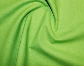 May include: A bright green fabric with a smooth texture. The fabric is folded and draped, showing its soft and flowing nature.