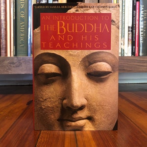 May include: A book titled "An Introduction to the Buddha and His Teachings" with a close-up image of the Buddha's face on the cover.