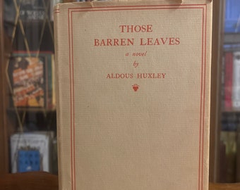 May include: A vintage hardcover book with a tan cover and red lettering. The title is "Those Barren Leaves" a novel by Aldous Huxley.