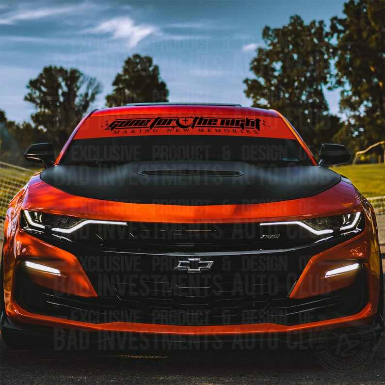 May include: A red sports car with a black windshield banner that reads "Game for the night making new memories".