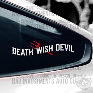 May include: A black and white sticker with the text "DEATH WISH DEVIL" in a bold font. A red trident is positioned to the right of the text. The sticker is on a black car window.