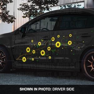 Peut inclure: Une voiture noire avec un autocollant de tournesol sur le côté conducteur. L'autocollant représente une branche brune avec des tournesols jaunes et des feuilles vertes. L'autocollant est sur le côté de la voiture, sous les fenêtres.