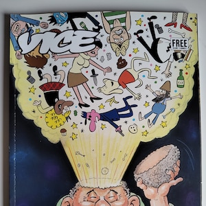 May include: A yellow and black comic book cover with the word "VICE" in large, bold letters. The cover features a cartoon illustration of a man with a large head and a surprised expression. The man's head is exploding with stars, hearts, and other symbols. The text "THE COMICS ISSUE" is printed at the bottom of the cover.