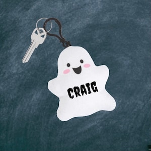 May include: White ghost-shaped plush keychain with a smiling face and the name "CRAIG" printed on the front.