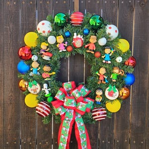 Peanuts Holiday Wreath with  remote controlled battery powered color  led lights, Wreath features Snoopy, Charlie Brown and 8 other Friends