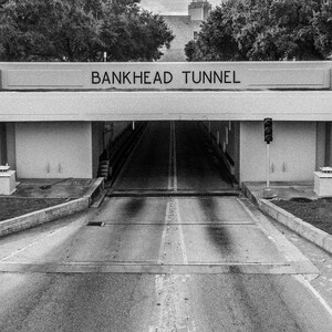 May include: A black and white photo of a tunnel entrance with the words "BANKHEAD TUNNEL" above the entrance.