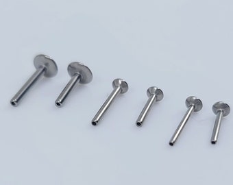 Puede incluir: Un conjunto de seis anillos de nariz plateados de diferentes longitudes. Los anillos están hechos de acero quirúrgico y tienen una parte superior plana y circular.