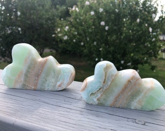 May include: Two green and brown cloud-shaped carved onyx stones.