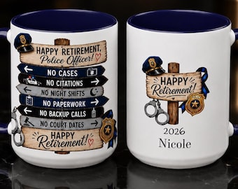 May include: Two white ceramic mugs with dark blue interiors and handles. One mug features a wooden signpost graphic with text listing retirement benefits like no cases or paperwork. The other mug displays a police hat, handcuffs, and the name Nicole 2026.