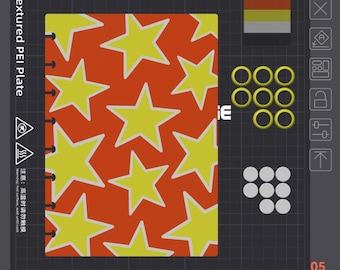 May include: A rectangular textured PEI plate featuring a repeating pattern of yellow stars with white outlines on an orange background. The plate includes a grid layout, a color swatch, eight yellow rings, eight white circles, and text labels.
