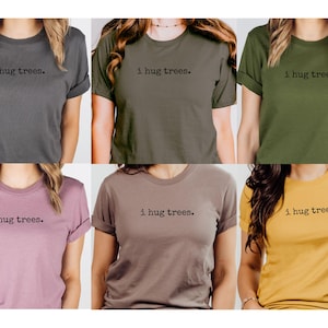 以下が含まれることがあります： 前面に「i hug trees.」の文字が印刷された、6色の異なるTシャツです。