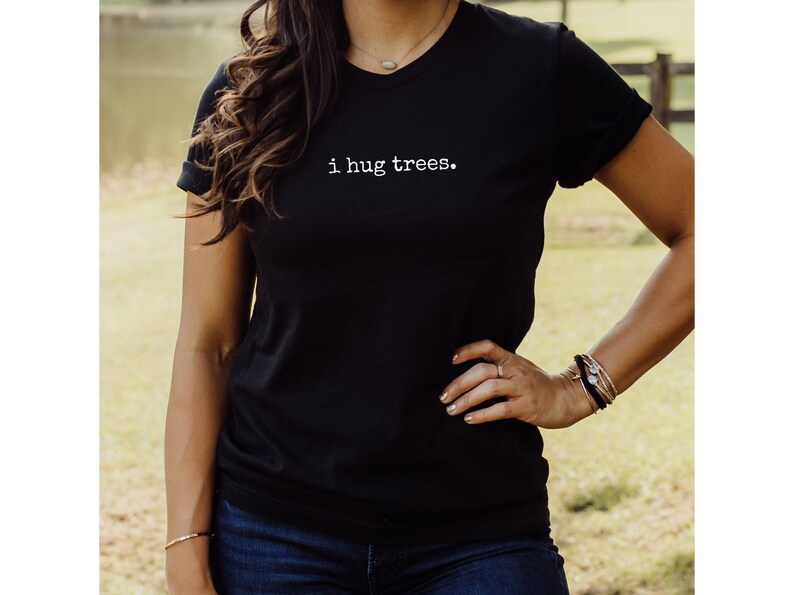 May include: A black t-shirt with the text "i hug trees." printed in white on the front.