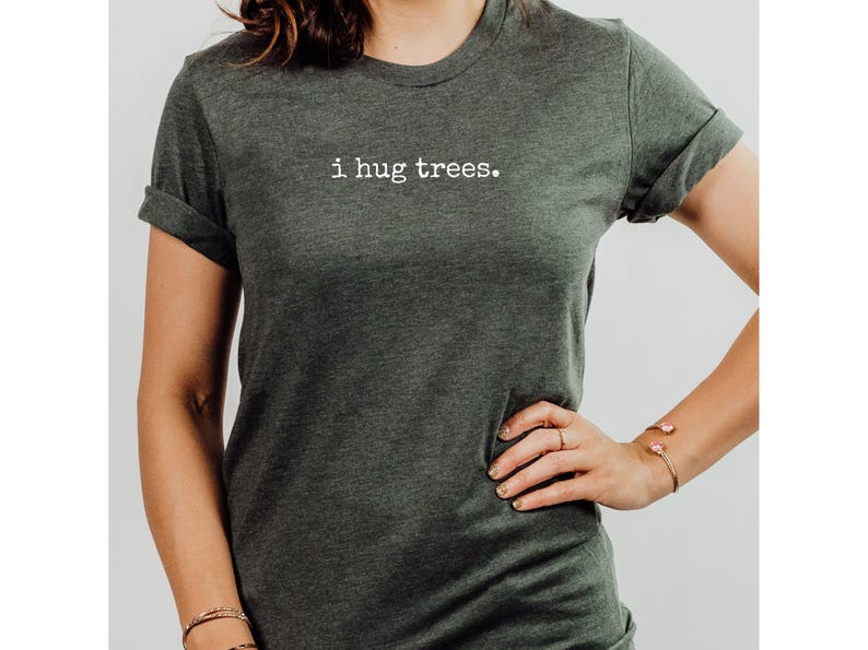May include: A dark green t-shirt with the text "i hug trees." printed in white on the front.
