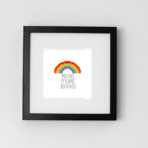 May include: A framed print with a rainbow pixel art design and the text "Read More Books".