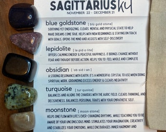May include: A set of five crystals for the Sagittarius zodiac sign. The crystals are blue goldstone, lepidolite, obsidian, turquoise, and moonstone. The crystals are arranged on a white card with the name of each crystal and its properties listed. The card also includes the Sagittarius zodiac symbol and the dates for the Sagittarius zodiac sign.