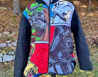 May include: A quilted bomber jacket with a comic book style design featuring Star Wars characters. The jacket has black quilted sleeves and a black collar. The front panels display images of Darth Vader, Stormtroopers, and other characters in vibrant colors.