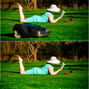 May include: A woman wearing a white sun hat lies on a green lawn reading a book. A glass of red wine and a red apple are on the grass beside her.