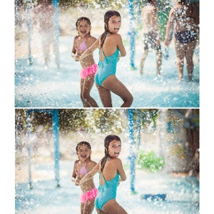 May include: Two girls in swimsuits are playing in a water park with water spraying around them. The girl in the front is sticking her tongue out and smiling.
