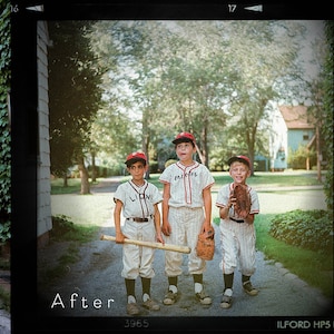 May include: Three boys wearing baseball uniforms and caps walk down a path. They are holding baseball bats and gloves. The boys are in front of a house with a green lawn.