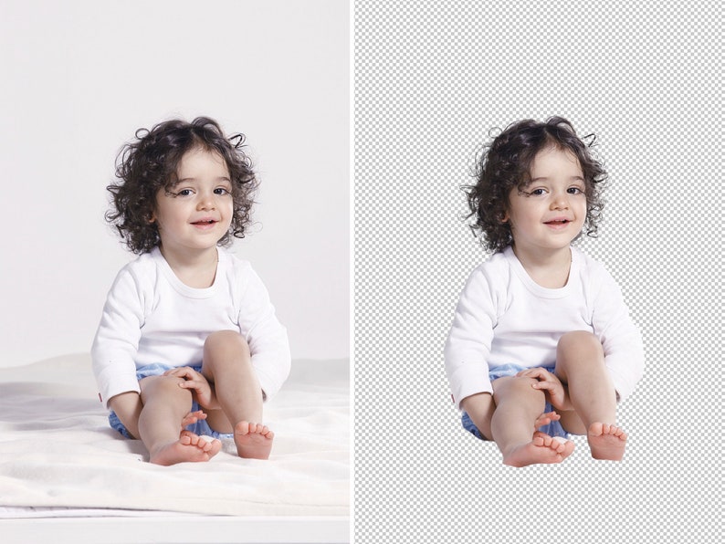 May include: A young child with curly brown hair is sitting on a white blanket. The child is wearing a white long-sleeved shirt and blue and white patterned shorts. The child is smiling and looking at the camera.
