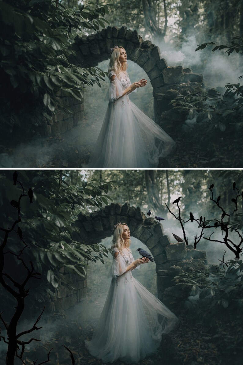 May include: A woman in a white dress stands in a misty forest, with a stone archway behind her. She is holding a small black bird in her hand. There are several black birds perched on branches in the background.