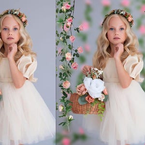May include: A young girl in a white tulle dress with a floral crown holds a wicker basket filled with pink and white flowers. The background is a blurred image of pink flowers and greenery.