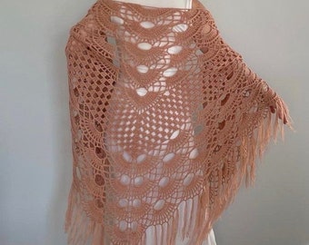 May include: A peach-colored crocheted shawl with a delicate lace pattern and fringe trim.