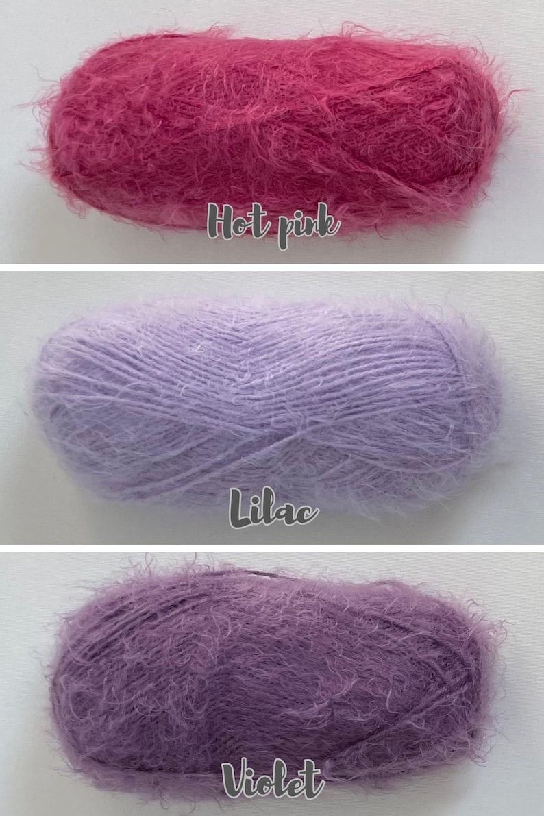 Op de afbeelding: Drie pluizige garenbollen in roze, lavendel en paarse tinten. De bovenste bol is felroze, de middelste is lila en de onderste is violet. Elke bol heeft een zachte, fuzzy textuur, perfect voor brei- of haakprojecten.