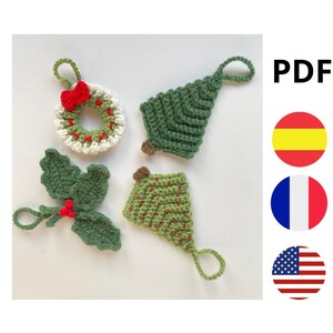 Puede incluir: Adornos navideños de ganchillo en verde, blanco y rojo. El conjunto incluye una corona con un lazo rojo, un árbol de Navidad, una ramita de acebo y una forma de árbol estilizada con puntos rojos. Cada adorno tiene un lazo para colgar.