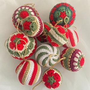 May include: A collection of nine crocheted Christmas ornaments in red, green, white, and gold. The ornaments are all different designs, including stripes, swirls, and geometric patterns.
