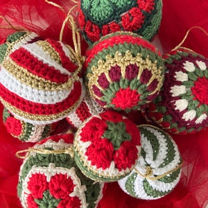 May include: A collection of eight crocheted Christmas ornaments in red, green, white, and gold. The ornaments are decorated with various patterns, including stripes, snowflakes, and flowers.