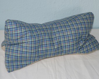 May include: A blue and green plaid pillow with a white border. The pillow is rectangular and has a slightly curved shape.