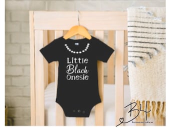 Lilla svarta body: Babyflicka med halsband
