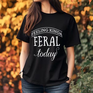 May include: Black t-shirt with white text that reads "Feeling Kinda Feral Today".