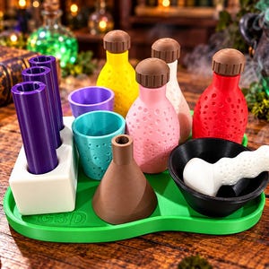 May include: A green tray holds a collection of laboratory-style items including three purple cylinders in a white stand, a yellow bottle, a pink bottle, a red bottle, a white bottle, a purple cup, a teal cup, a brown funnel, and a black mortar and pestle.