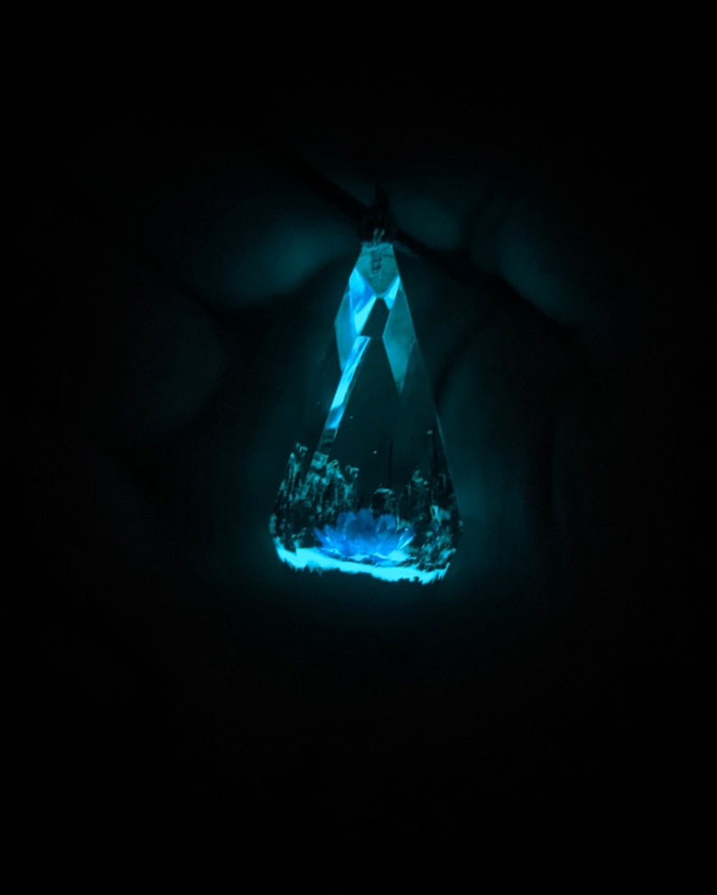May include: A blue crystal pendant with a faceted design, glowing in the dark.