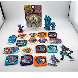 Könnte beinhalten: Eine Sammlung von Pokémon-Spielzeugen und Sammlerstücken. Das Set enthält Figuren von Lucario und Riolu sowie verschiedene Spielmarken und Aufkleber. Die Verpackung weist japanischen Text auf. Die Farbpalette umfasst Blau, Gelb und Orange.