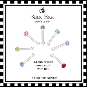 May include: A set of 1.5mm crystal nose studs with ball ends in various colours, including red, blue, green, pink, and purple. The studs are made of sterling silver and are displayed on a white background with the text "Kate Bee Jewellery" and "1.5mm crystal nose stud with ball" and "STERLING SILVER".