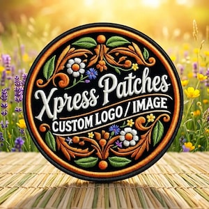 May include: Embroidered patch with the text "Xpress Patches CUSTOM LOGO / IMAGE" in white script. The patch is round with a black background and an orange border. Floral and leaf designs in orange, green, white, and blue decorate the patch.
