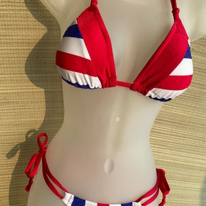 May include: Red, white, and blue striped bikini top and bottom. The top is a triangle style with adjustable straps. The bottom is a cheeky style with ties on the sides.
