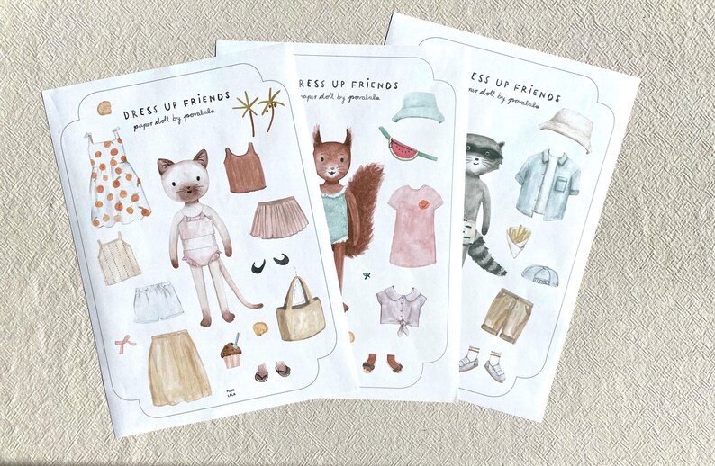 May include: Three paper doll sets with animal characters and clothing. The sets include a cat, squirrel, and raccoon, each with outfits like dresses, skirts, shirts, and accessories. The text "DRESS UP FRIENDS" is at the top of each set.