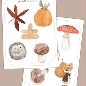 Könnte beinhalten: Zwei bedruckbare Blätter mit Aquarellillustrationen von Herbstdekorationen. Das erste Blatt enthält ein braunes Blatt, einen orangefarbenen Kürbis, einen Igel und einen Pilz. Das zweite Blatt zeigt einen rot-weißen Pilz, eine Birne und einen Bären, der die Birne hält. Der Text lautet "AUTUMN DECORATIONS".
