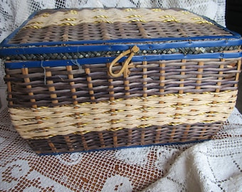 May include: A woven wicker storage box with a blue trim and a gold rope accent. The box has a hinged lid with a metal latch.