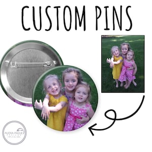 May include: Custom pins with a photo of three young girls in yellow and pink dresses. The pins are round with a metal backing and a pin clasp. The text "CUSTOM PINS" is at the top of the image.