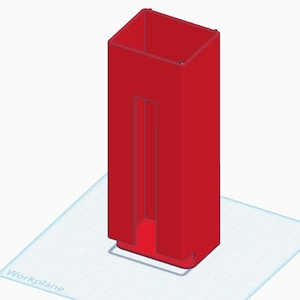 May include: A 3D-rendered, red, rectangular object with a hollow, rectangular interior. The object is standing upright on a light blue surface. The word "Workplane" is visible on the surface.
