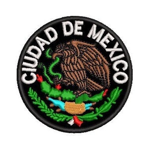 Puede incluir: Un parche circular negro y blanco con el texto "CIUDAD DE MEXICO" alrededor del borde. El centro del parche presenta un águila marrón con una serpiente verde en su pico, de pie sobre un cactus con hojas verdes. El águila está rodeada por una corona de laurel verde.