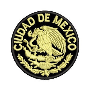 Peut inclure: Un écusson brodé noir et or avec le texte "CIUDAD DE MEXICO" autour du bord. Le centre de l'écusson présente un aigle stylisé avec un serpent dans son bec.