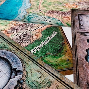 May include: A close-up of a game board with a map of a fantasy world. The map features various locations, including "Mere of Dead Men", "Sword Mountain", and "Yptgarden Forest".