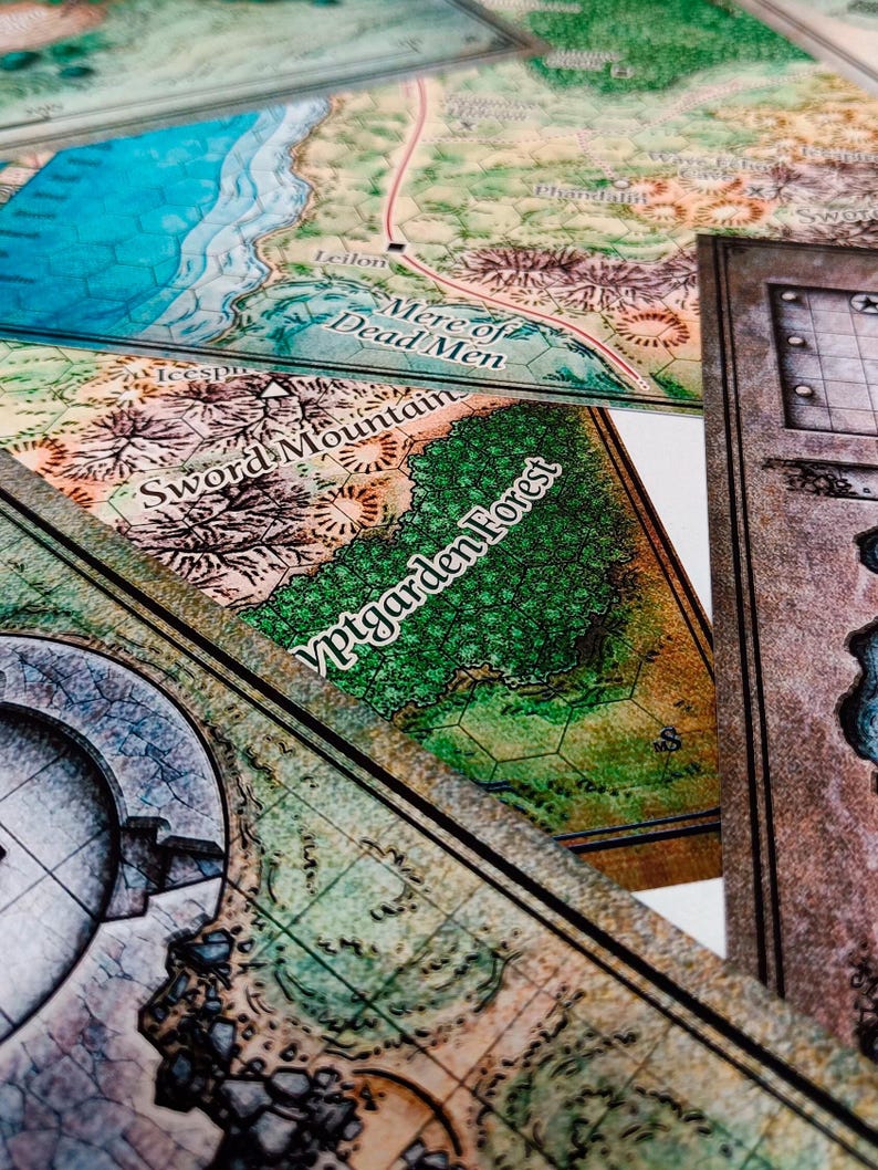 May include: A close-up of a game board with a map of a fantasy world. The map features various locations, including "Mere of Dead Men", "Sword Mountain", and "Yptgarden Forest".